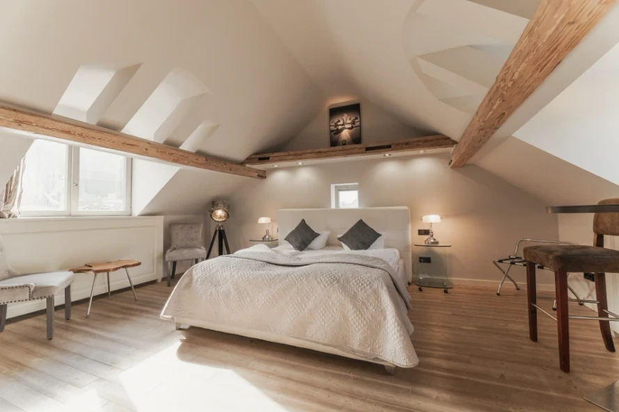 Ferienwohnung in der Heidelberger Altstadt von BS Suites, mit großem Doppelbett, Dachschräge und Stühlen 